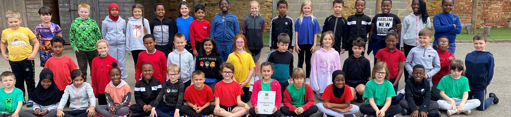 Pupils from Spring Lane Primary School, Northampton sitting in the school playground.