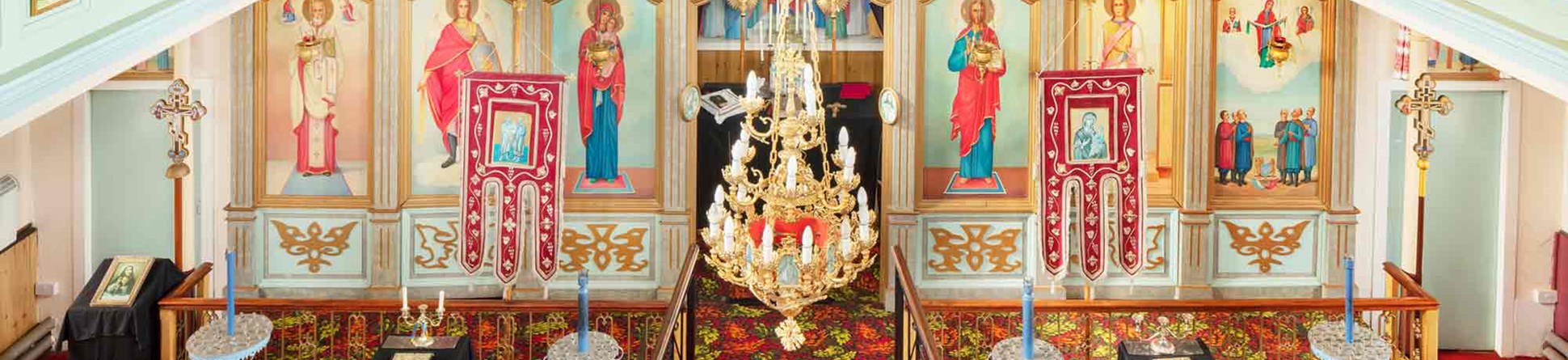 Interior of church shows brightly coloured ‘iconostasis’, a screen of icons depicting Christ, Mary, and the saints. 