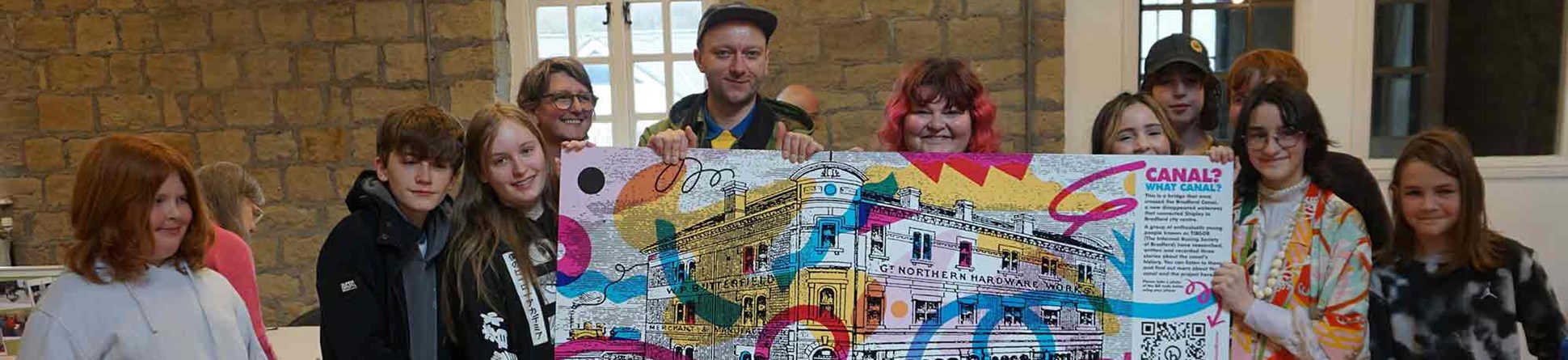 Group of people holding a large banner depicting the role of canals