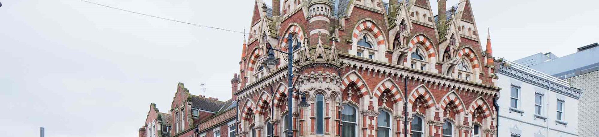 Ornate red and white brick building on the corner of a street