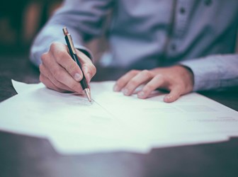 Person writing on documents