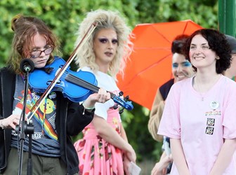 A person playing a violin in an open-air performance. 